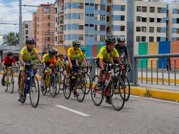 Group of cyclists in matching jerseys riding together down a city road